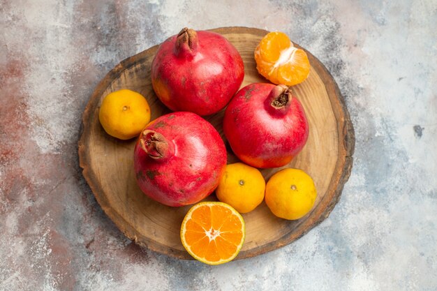 Top view fresh tangerines with red pomegranates on light background