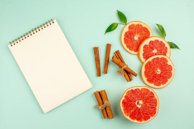 Top view fresh tasty grapefruits with cinnamon on light-blue background