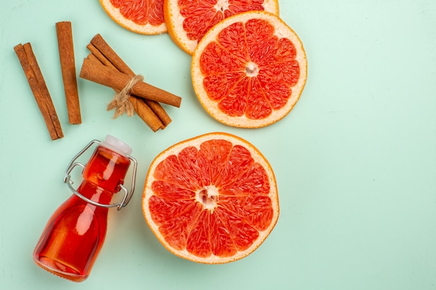 Free photo top view fresh tasty grapefruits with cinnamon on the light-blue background