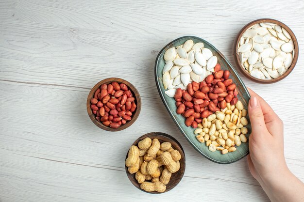 Top view fresh tasty peanuts with white seeds inside plate on white table