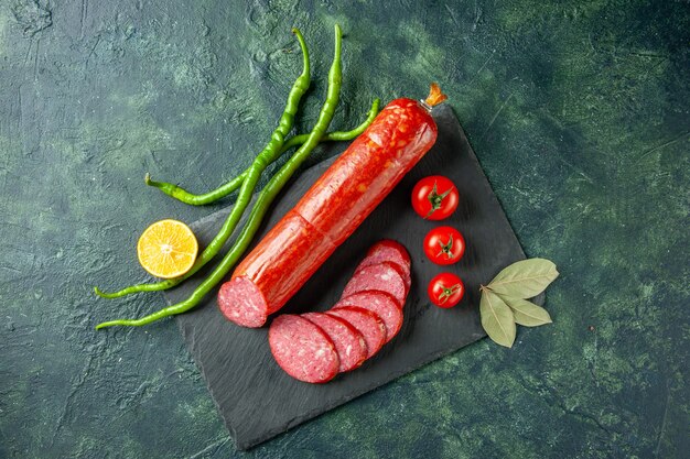 上面図青い背景に赤いトマトと新鮮なおいしいソーセージパン肉食品ハンバーガーサンドイッチパンカラーサラダ