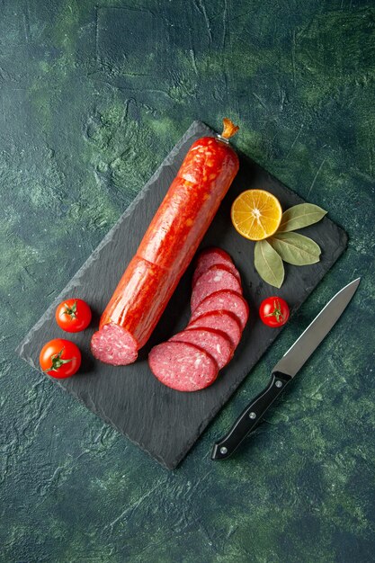 Top view fresh tasty sausage with tomatoes on a blue background meat food burger sandwich bread bun color