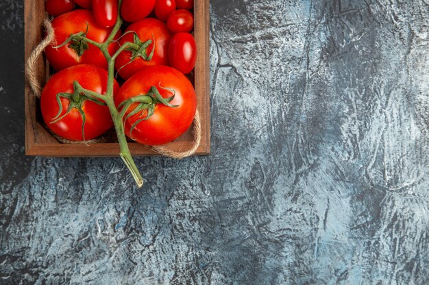 Top view fresh tomatoes with cherry ones inside box