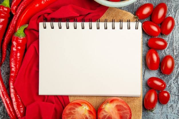 Top view fresh tomatoes with peppers and notepad