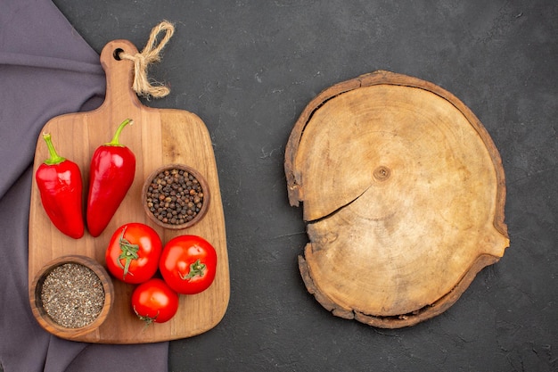 Top view of fresh tomatoes with seasonings on black table