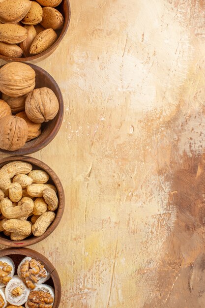 Вид сверху различных свежих орехов, выложенных на деревянном столе