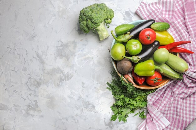 Top view fresh vegetable composition inside plate on white background