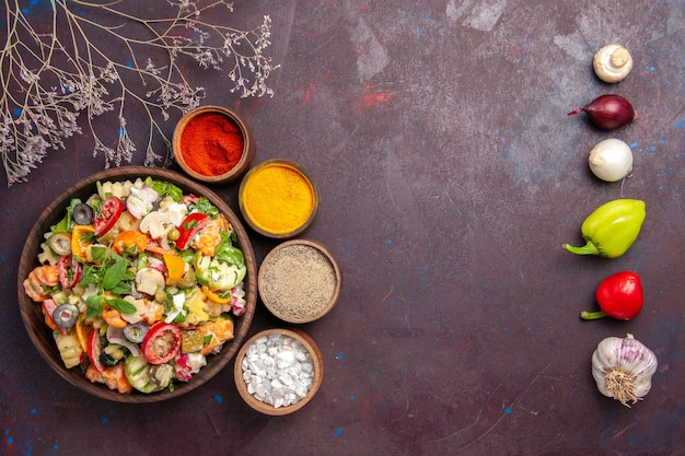 Top view of fresh vegetable. salad with different seasonings on black