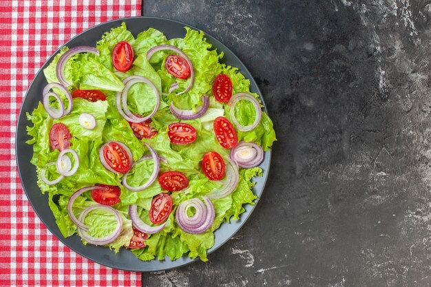 Top view fresh vegetable salad with green salad onions and tomatoes on gray background ripe food health color salad meal photo diet
