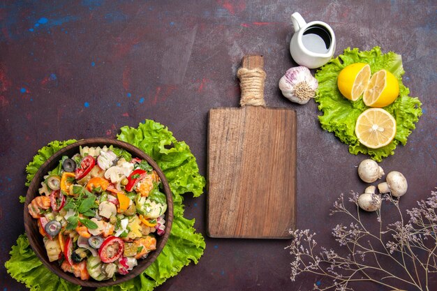 Top view of fresh vegetable. salad with lemon slices and green salad on black