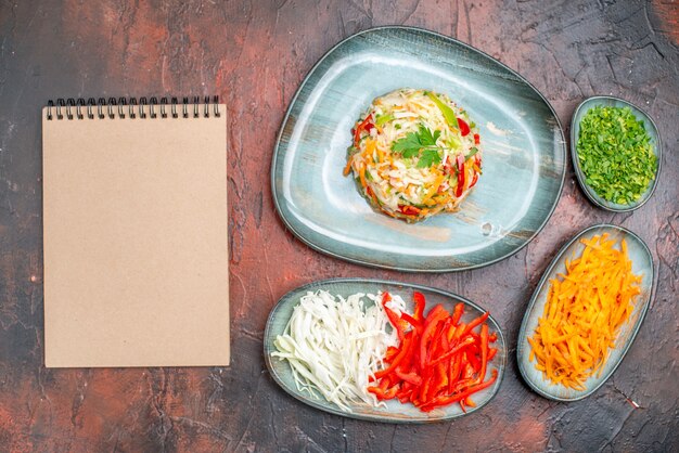 Free photo top view fresh vegetable salad with sliced carrot cabbage and bell-peppers on dark table