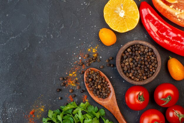 Top view fresh vegetables black pepper in small bowl and wooden spoon on table free space