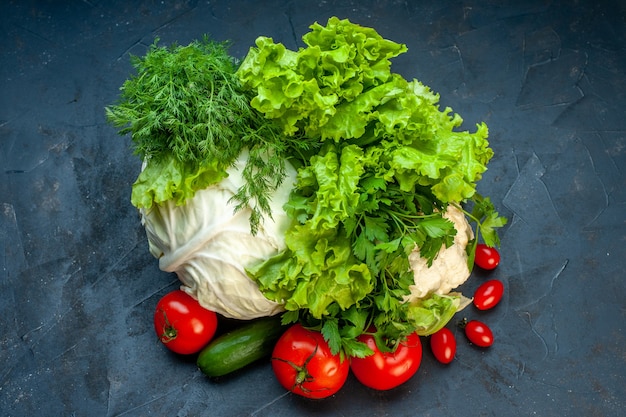 Top view fresh vegetables cabbage parsley bell peppers lettuce dill cauliflower tomatoes on dark surface