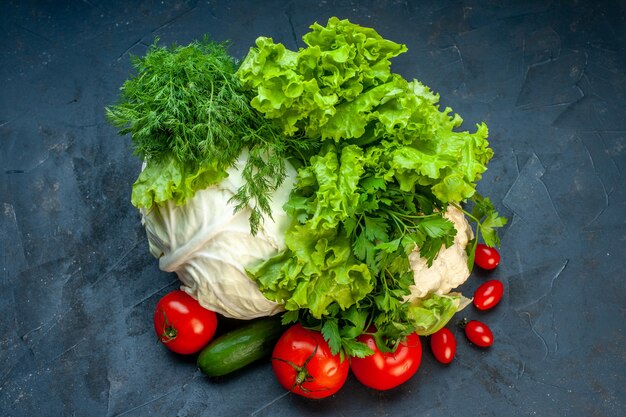 Top view fresh vegetables cabbage parsley bell peppers lettuce dill cauliflower tomatoes on dark surface