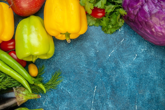 Foto gratuita vista dall'alto verdure fresche pomodorini cumcuat coriandolo cavolo rosso melanzane sul tavolo blu posto libero