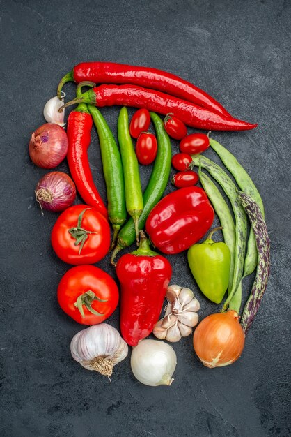 Top view fresh vegetables composition on the grey table ripe fresh color salad