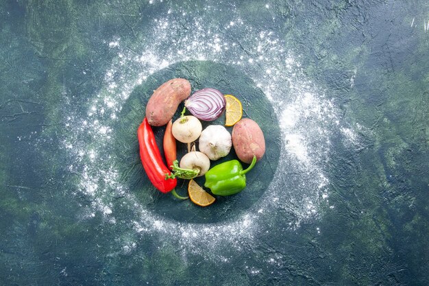 Top view fresh vegetables garlic pepper onion and potatoes on dark blue background ripe salad food plant vegetable meal