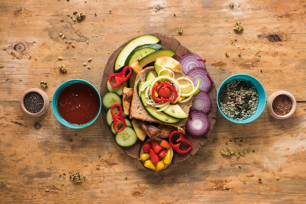新鮮な野菜やサンドイッチの食材を木製の背景に配置のトップビュー