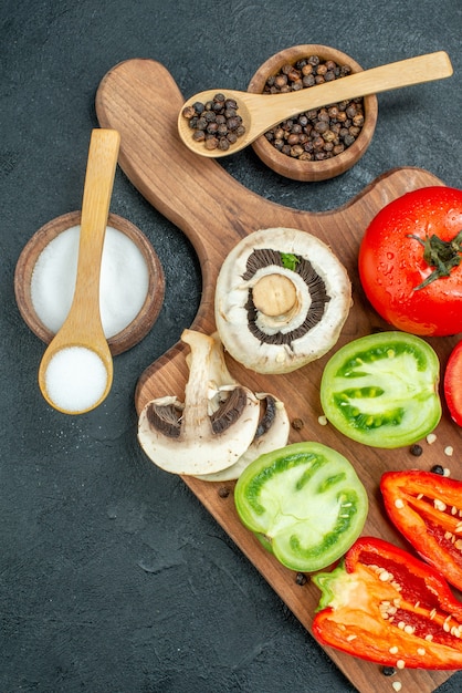 Top view fresh vegetables mushrooms red and green tomatoes bell peppers on cutting board