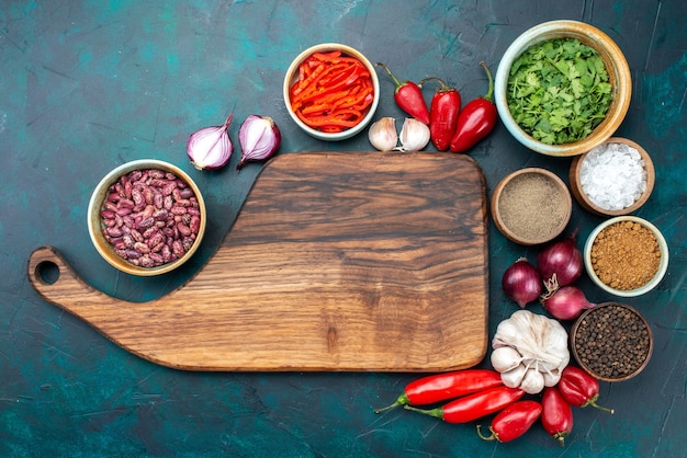 Вид сверху свежих овощей, лука, чеснока, перца с зеленью и фасолью на темном, овощном ингредиенте пищевого блюда