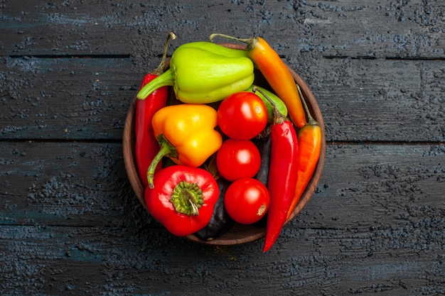 Top view fresh vegetables tomatoes and pepper on the dark desk