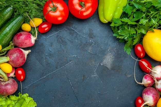 Top view fresh vegetables tomatoes radish lemon cucumber parsley cherry tomatoes on dark surface copy place