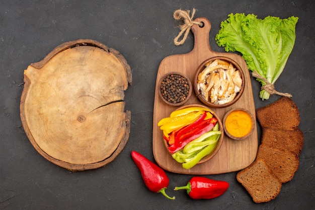 Top view of fresh vegetables with black bread on black