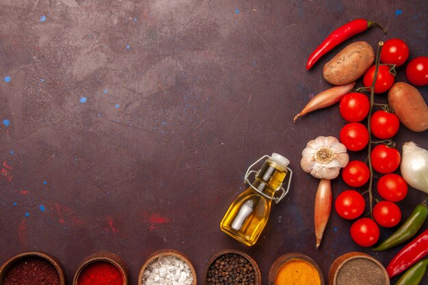 Top view fresh vegetables with different seasonings on dark-purple space