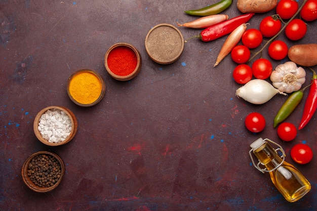 Free photo top view fresh vegetables with different seasonings on a dark space