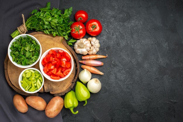 Top view of fresh vegetables with greens on black