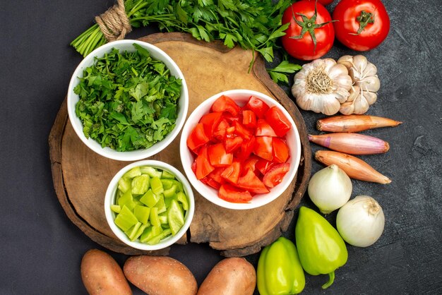 Top view of fresh vegetables with greens on black