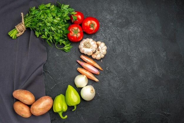 Top view of fresh vegetables with greens on black