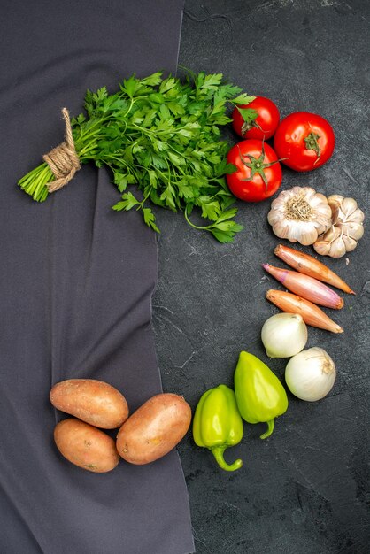 Top view of fresh vegetables with greens on black