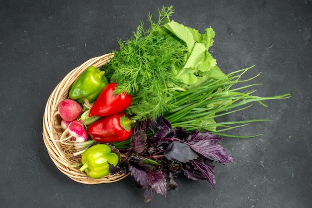 Top view fresh vegetables with greens on dark background