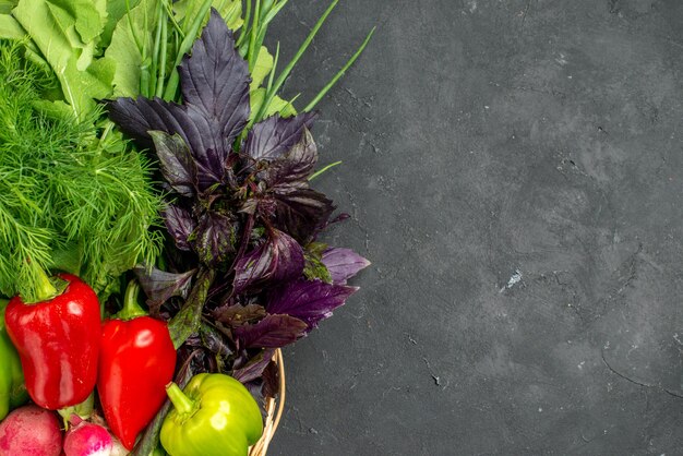 Top view fresh vegetables with greens on dark background