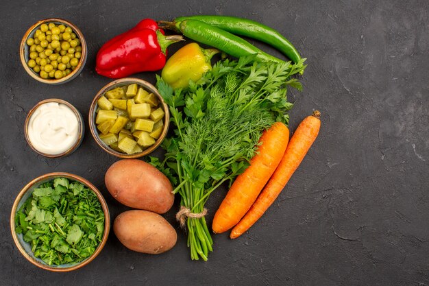 Top view of fresh vegetables with greens on dark surface