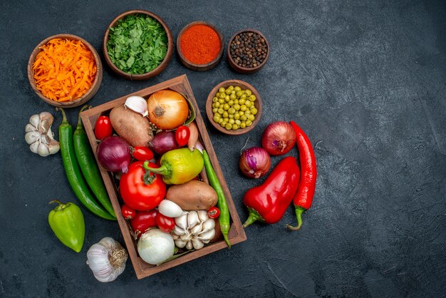 Top view fresh vegetables with greens on a dark table color ripe salad vegetable