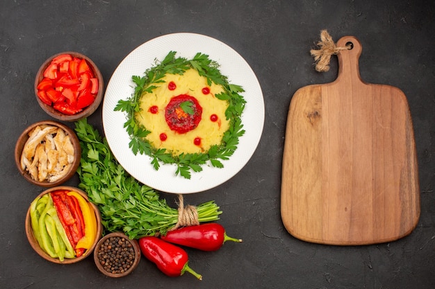 Top view of fresh vegetables with greens and potato dish on black