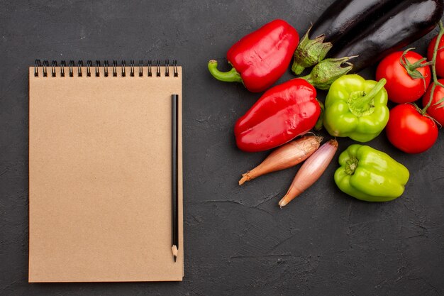 灰色の背景にメモ帳と新鮮な野菜の上面図サラダ野菜の食事の健康