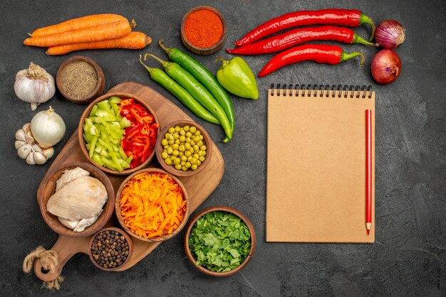 Top view fresh vegetables with pepper and garlic on dark table