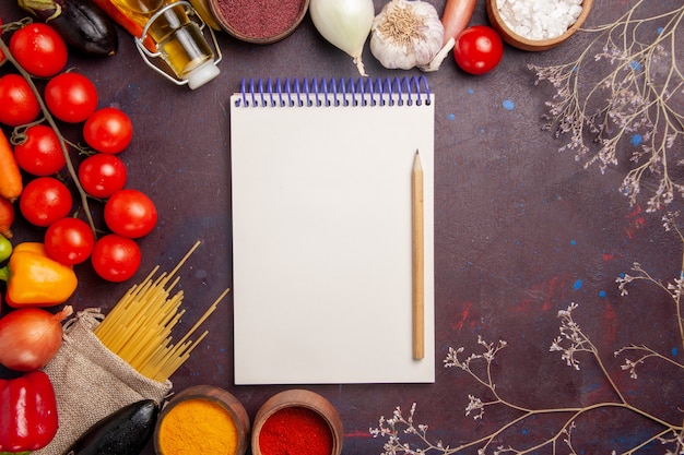 Free photo top view fresh vegetables with raw italian pasta and seasonings on the dark space