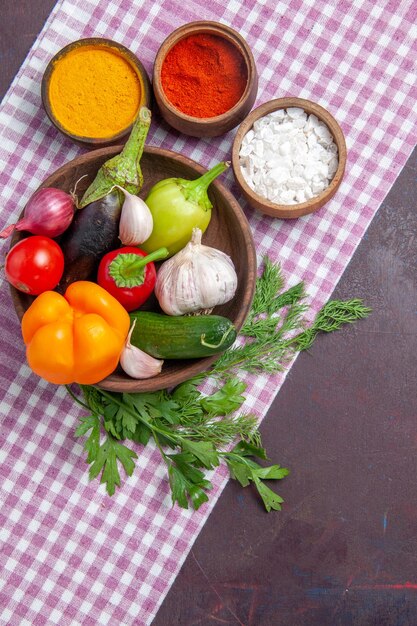 Top view fresh vegetables with seasonings on a dark surface ripe salad health food