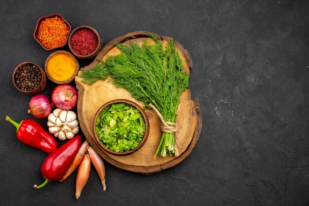 Top view fresh vegetables with seasonings and greens on a dark surface salad health ripe meal vegetable