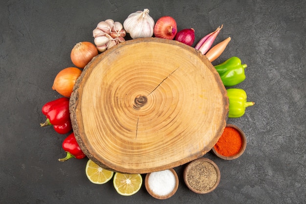 Top view fresh vegetables with seasonings on a grey background