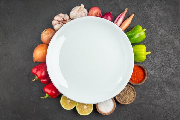 Top view fresh vegetables with seasonings on grey background