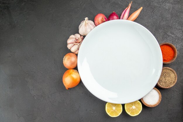 Top view fresh vegetables with seasonings on grey background