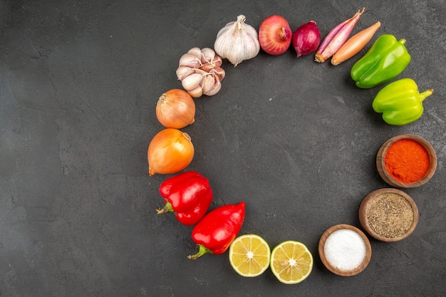 Top view fresh vegetables with seasonings on the grey background