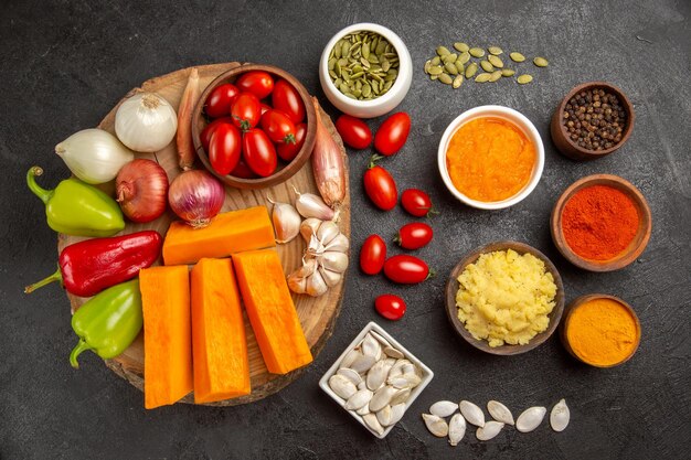 Top view fresh vegetables with sliced pumpkin and garlic on a grey background color seed fresh ripe salad