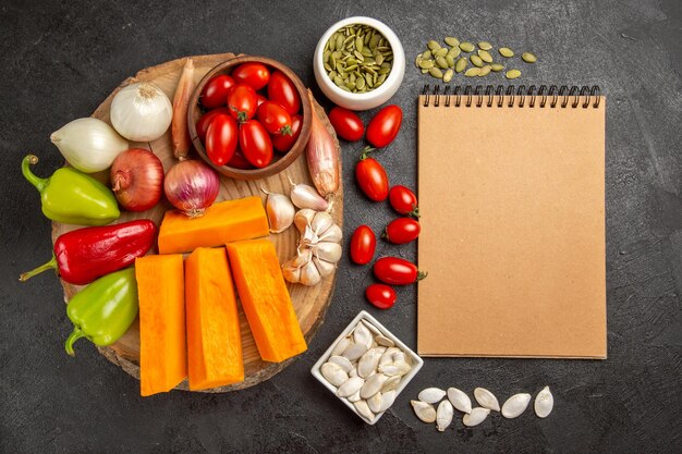 Top view fresh vegetables with sliced pumpkin and garlic on grey background color seed fresh ripe salad