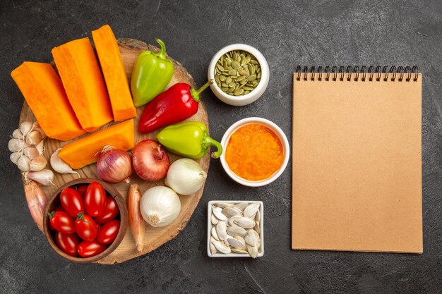 Top view fresh vegetables with sliced pumpkin on a grey background fresh color ripe salad